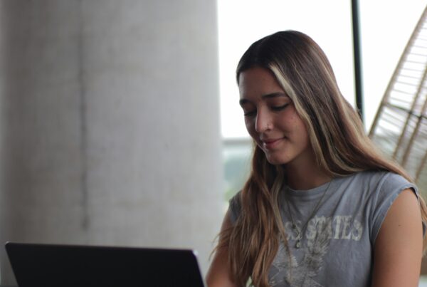 Young woman using laptop, concentrating on online studies indoors.